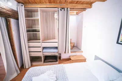 a bedroom with a bed and a wooden ceiling at Au pied des remparts- Maison de caractère-3 Ch-AC in Carcassonne