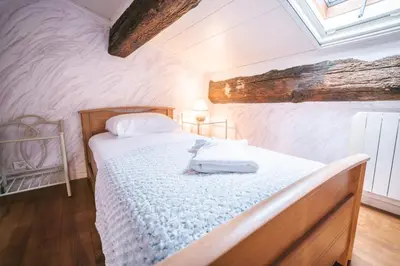 a bedroom with a bed in a room with a ceiling at Au pied des remparts- Maison de caractère-3 Ch-AC in Carcassonne