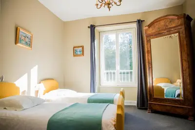 a bedroom with two beds and a mirror at Domaine de Gondal, demeure de charme in Palaja