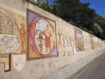 a wall with paintings on the side of a street at Domaine de Gondal, demeure de charme in Palaja