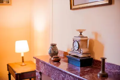 a table with a clock and a lamp on it at Domaine de Gondal, demeure de charme in Palaja