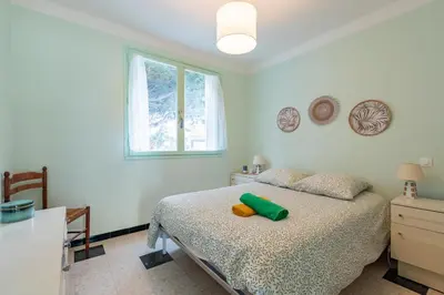 a bedroom with a bed with a green pillow on it at Les Jacinthes - Spacious sea view in Port-la-Nouvelle