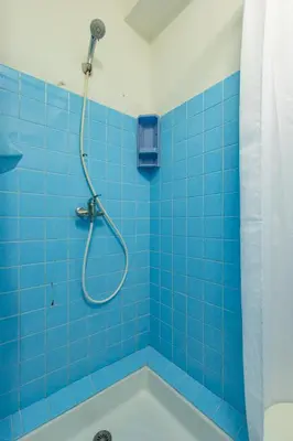 a blue tiled bathroom with a shower and a tub at Les Jacinthes - Spacious sea view in Port-la-Nouvelle