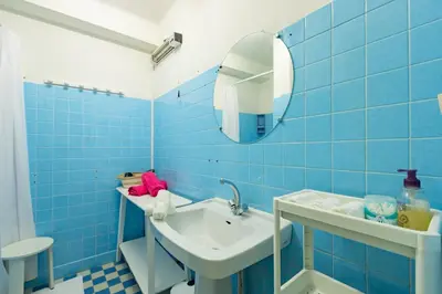 a blue tiled bathroom with a sink and a mirror at Les Jacinthes - Spacious sea view in Port-la-Nouvelle