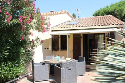 a table and chairs in front of a house at Maison 2 pièces mezzanine - Gruissan GN020-071 in Gruissan