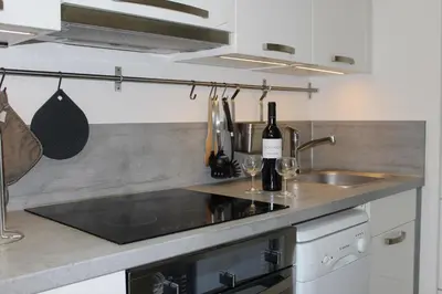 a kitchen with a sink and a counter with wine bottles at Maison 2 pièces mezzanine - Gruissan GN020-071 in Gruissan