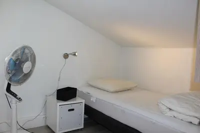 a room with a bed with a fan and a night stand at Maison 2 pièces mezzanine - Gruissan GN020-071 in Gruissan