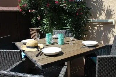 a wooden table with bowls and wine glasses on it at Maison 2 pièces mezzanine - Gruissan GN020-071 in Gruissan