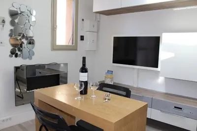 a bottle of wine sitting on a table with two glasses at Maison 2 pièces mezzanine - Gruissan GN020-071 in Gruissan
