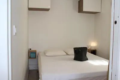 a bedroom with a white bed with a black bag on it at Maison 2 pièces mezzanine - Gruissan GN020-071 in Gruissan