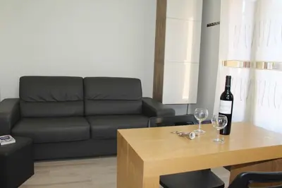 a living room with a couch and a bottle of wine on a table at Maison 2 pièces mezzanine - Gruissan GN020-071 in Gruissan