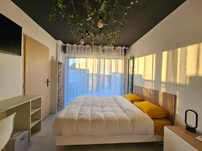 a bedroom with a large bed and a window at Evasion balneo in Narbonne