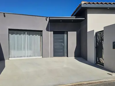 a house with two garage doors and a driveway at Evasion balneo in Narbonne
