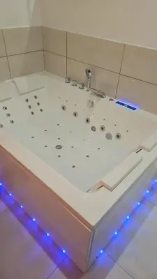 a white bath tub with blue lights on the floor at Evasion balneo in Narbonne