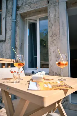a wooden table with two glasses of wine on it at Le Château de La Seigne près de Carcassonne in Villemoustaussou
