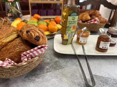 a table with a basket of bread and a plate of fruit at Le Château de La Seigne près de Carcassonne in Villemoustaussou