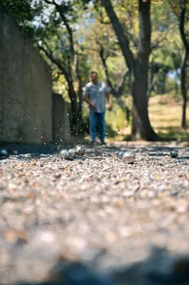 a man walking down a gravel road with trees at Le Château de La Seigne près de Carcassonne in Villemoustaussou
