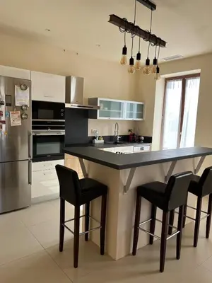 a kitchen with a large island with black bar stools at Charming Master House with Private Pool in Quarante
