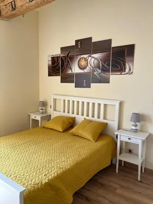 a bedroom with a bed with two tables and two paintings at Charming Master House with Private Pool in Quarante
