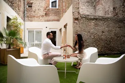 a man and woman sitting at a table in a room at La Villa Lova - Loveroom avec spa privatif à Pamiers in Pamiers