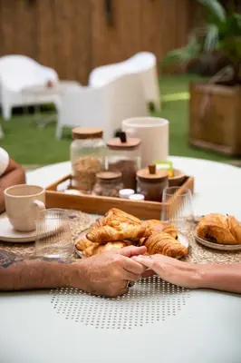 a person holding a tray of pastries on a table at La Villa Lova - Loveroom avec spa privatif à Pamiers in Pamiers