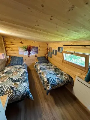 a bedroom with two beds in a log cabin at Oyana in Montgradail