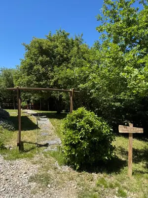 a wooden sign next to a bush with a cross at Oyana in Montgradail