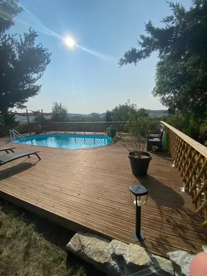 a wooden deck with a swimming pool in a yard at Oyana in Montgradail