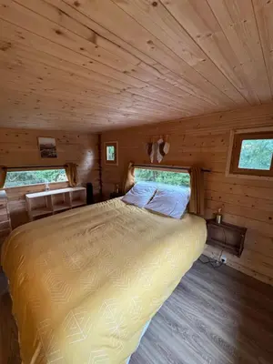 a bedroom with a bed in a wooden cabin at Oyana in Montgradail