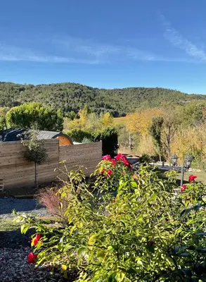 a garden with flowers and a wooden fence at A l ombre des pods Chardonnay et spa in Saint-Hilaire