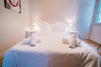 a bedroom with a white bed with towels on it at Magnifique T4- toit terrasse-Cosy-Centre ville-AA in Carcassonne