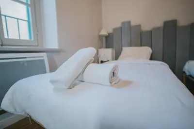 a hospital room with two beds with white blankets at Magnifique T4- toit terrasse-Cosy-Centre ville-AA in Carcassonne