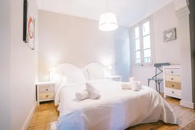 a bedroom with a white bed with two stuffed animals on it at Magnifique T4- toit terrasse-Cosy-Centre ville-AA in Carcassonne