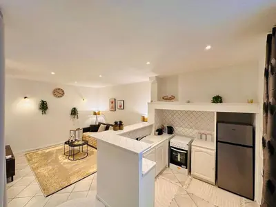 a kitchen with white appliances and a living room at Le Refuge de Saint-Vincent - T2 Hyper Centre - Proche Gare in Carcassonne