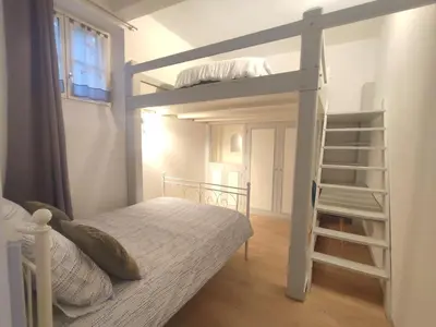 a bedroom with a bunk bed with a ladder at Le Chartrand- Centre-ville- Séjour inoubliable! in Carcassonne