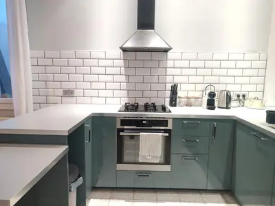 a kitchen with green cabinets and a stove top oven at Le Chartrand- Centre-ville- Séjour inoubliable! in Carcassonne