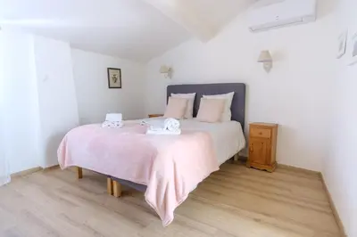 a bedroom with a bed with two towels on it at Maison Charmante au coeur de la circulade-Patio-AB in Bram