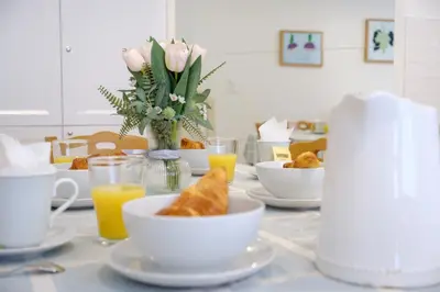 a table with cups and plates of food and orange juice at Maison Charmante au coeur de la circulade-Patio-AB in Bram