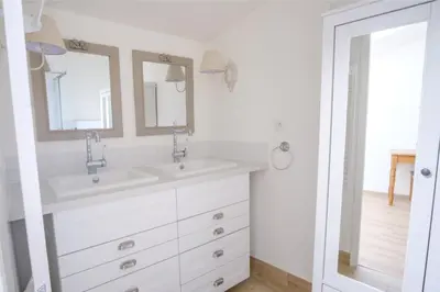 a white bathroom with two sinks and a mirror at Maison Charmante au coeur de la circulade-Patio-AB in Bram