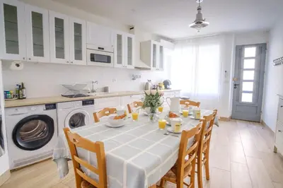 a kitchen with a table with chairs and a washing machine at Maison Charmante au coeur de la circulade-Patio-AB in Bram