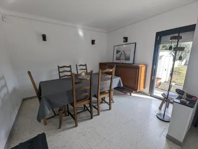 a dining room with a table and chairs and a desk at Maison T4 110m² avec jardin clos, à 1500m de la plage - FR-1-797-60 in Port-la-Nouvelle