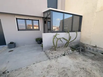 a cactus in front of a building with a window at Maison T4 110m² avec jardin clos, à 1500m de la plage - FR-1-797-60 in Port-la-Nouvelle