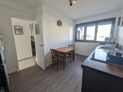 a kitchen and dining room with a table and a table at Maison T4 110m² avec jardin clos, à 1500m de la plage - FR-1-797-60 in Port-la-Nouvelle