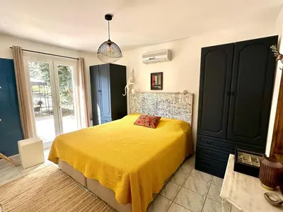 a bedroom with a bed with a yellow blanket at Carcassonne Lake & Beach, Pool villa in Carcassonne