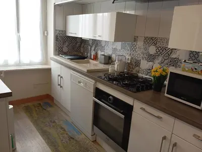 a kitchen with white cabinets and a stove top oven at Villa Laurence in Lézignan-Corbières