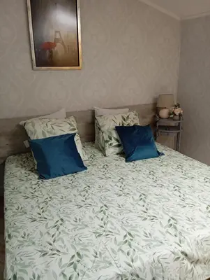 a bed with two blue pillows on top of it at Villa Laurence in Lézignan-Corbières