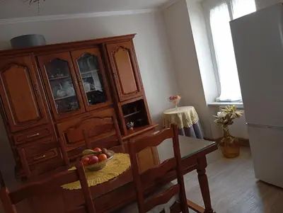 a kitchen with a wooden cabinet and a table with a bowl of fruit at Villa Laurence in Lézignan-Corbières