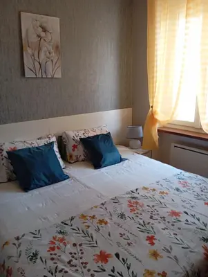 a bed with two blue pillows on top of it at Villa Laurence in Lézignan-Corbières