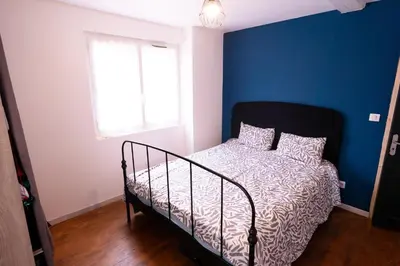 a bedroom with a bed with a blue wall at Chez Simon, au fil de l'eau in Revel
