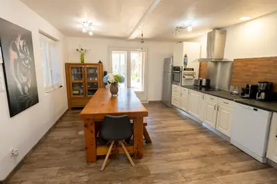 a kitchen with a wooden table in the middle at Chez Simon, au fil de l'eau in Revel
